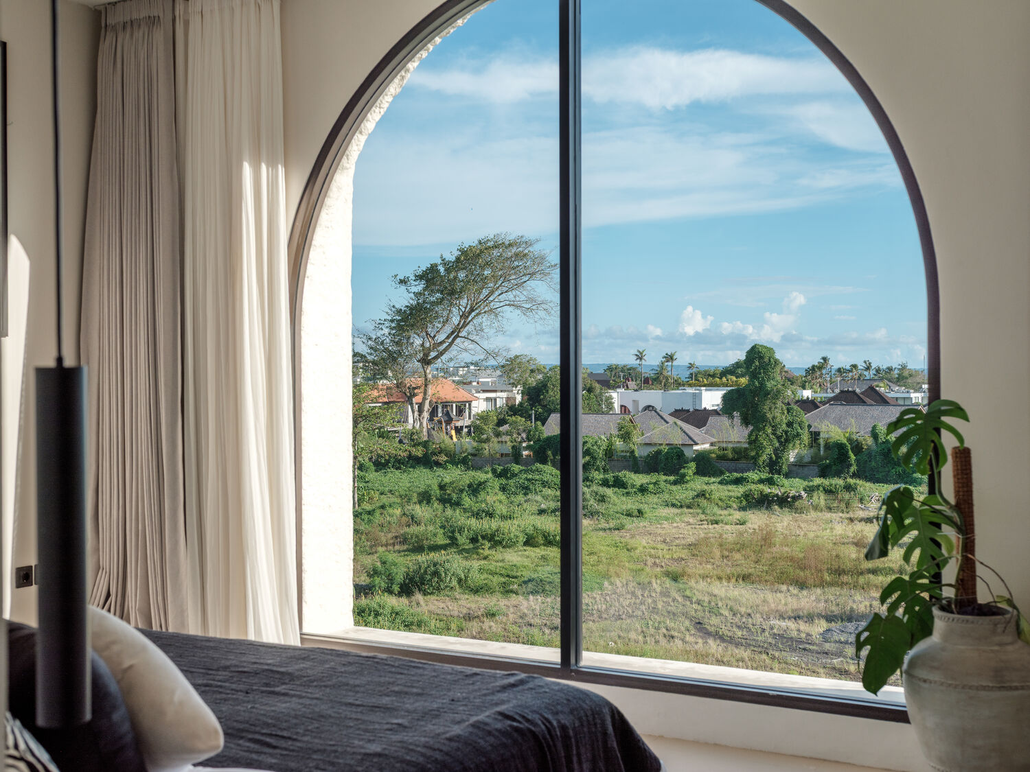 Master bedroom with arched window and rice-field view