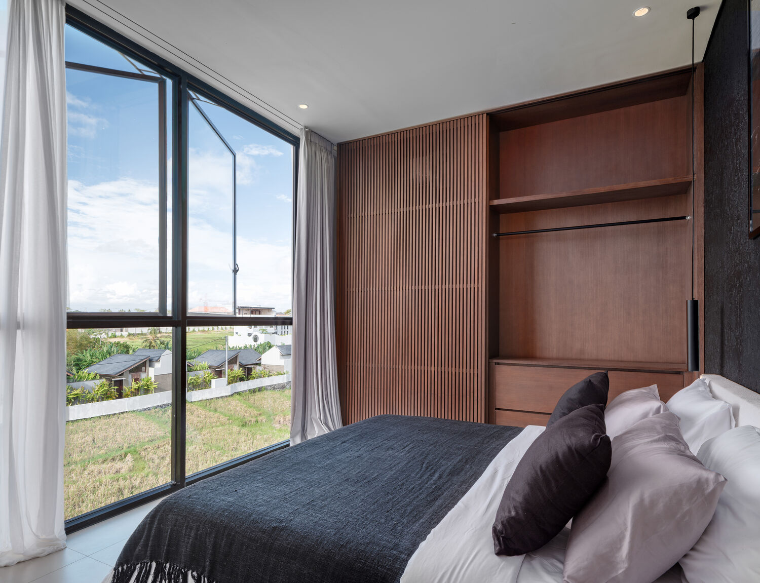 Bedroom with floor-to-ceiling window and rice-field view